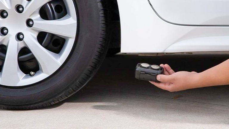 person putting car tracker on the car